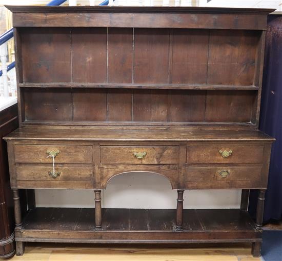 A mid 18th century oak dresser with later open shelved boarded top W188cm